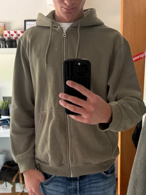 Olivgrön zip hoodie från weekday - Säljer en olivgrön hoodie med dragkedja och huva från weekday.