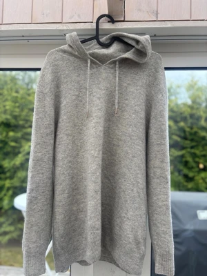 Mjuk och stilren hoodie från Garde Grisch - Säljer denna riktigt sköna hoodie från Garde Grish i en snygg ljusgrå färg. Perfekt för en avslappnad men fortfarande stilren look.  Hoodien har en mjuk och behaglig kvalitet som sitter riktigt bra på kroppen. Klassisk design med justerbara snören i huvan och ribbade muddar vid ärmslut och nederkant för en bra passform. Passar lika bra till vardags som till en chill outfit hemma eller på stan.