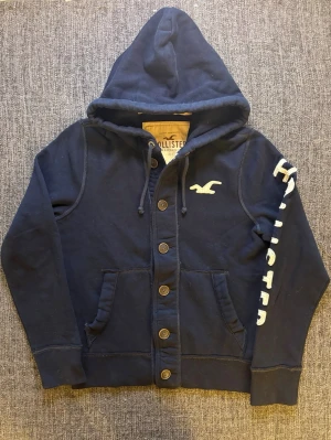 Hollister cardigan ~ 2000’s modell  - Sjukt eftertraktad Hollister cardigan i marinblå med knappar – 2000’s modell och sjukt sällsynt, stl M. Fint skick och sitter riktigt bra, perfekt till vardag 🌿  Kan även gå ner lite i pris vid snabb affär ✌️ Skickas inom 24h 📦