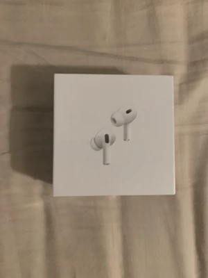 Apple AirPods Pro trådlösa hörlurar - Säljer ett par vita Apple AirPods Pro med stilren design och in-ear passform. Hörlurarna har aktiv brusreducering och levereras i originalförpackning. Perfekta för musik, poddar och samtal. Smidig laddningsetui ingår.