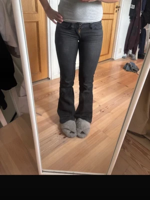 Bootcut svarta jeans med låg midja - Säljer ett par svarta bootcut jeans med låg midja och klassiska bakfickor. Dem är ifrån weekday i storlek 26/32. 