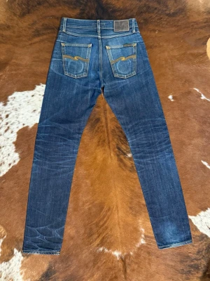 Mörkblå smala jeans från Nudie Jeans - Tjena! Säljer dessa straight selvage nudies i modellen SteadyEddie 1, fint skick med riktigt snygga fades, W28/L34, hör av dig vid funderingar!🙌