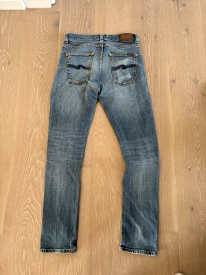 Nudie jeans - Säljer dessa riktigt snygga ljusblåa nudie jeansen i den populära modellen lean dean, storlek W30, L32!                                               De är i riktigt bra skick och har mycket vackra fades, även gjort en egen snygg fade på ena bakfickan! Perfekt nu till sommaren, hör av er vid funderingar😊