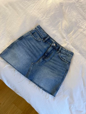 Blå jeanskjol från Weekday - Fin jeans kjol från ginatricot, använd 1 gång och är i väldigt fint skick. Säljer den då den blivit för liten. Den är i storlek 32 så hör av er om ni är sugna. Den kosta 399kr från början och säljer den för 100kr