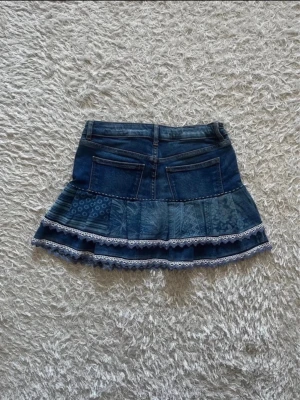 Jeanskjol med volang och spetsdetaljer - En jeanskjol omsydd från ett par jeans med volang och spetsdetaljer. 💕  Midjemått tvärsöver - 35cm Längd - 33cm