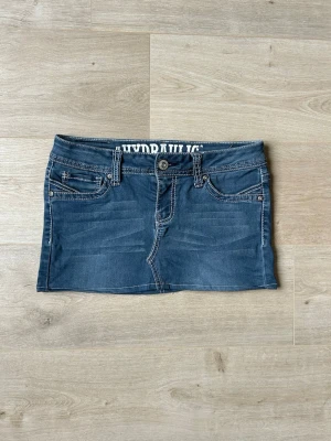 Blå Mini Skirt Y2K Jeanskjol Hydraulic Embroidery Storlek M  - Mycket fin kjol i blå färg. Kjolen är i mycket bra skick och sparsamt använda. |  Äkta som allt annat jag säljer! ✅ |  Storlek: M / 38  | Skick: Mycket Bra Skick | Färg: Blå | Märke: Hydraulic | Modell: Kjol |   Hör gärna av dig vid frågor så svarar jag så fort jag kan! 😁 |  (SKU - 142)