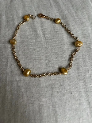 Handgjord fotlänk med sötvattenspärlor - Guldfärgad, handgjord fotlänk. 26,5 cm.