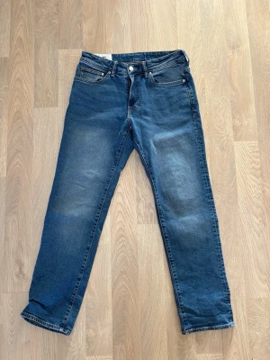 Blåa H&M jeans - Blåa H&M jeans med rak passform. Storlek W32, L 31. mycket bra skick, använda ett par gånger.