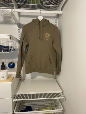 Grön Morris Hoodie  - Säljer denna riktigt snygga Morris hoodien. Tröjan har ett pyttelitet hål på den övre delen av höger arm men inget som syns och det går att laga. Kontakta för mer bilder eller funderingar!