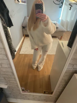 Vita leggings med slits nertill - Säljer ett par vita leggings med slits nertill på benen. De har en tight passform och är stretchiga, vilket gör dem riktigt bekväma. Perfekta att styla med en oversized tröja eller hoodie. Materialet känns mjukt och följsamt.