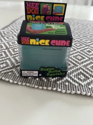 Nee Doh Nice Cube stressleksak - Rolig och färgglad stressleksak från NeeDoh. Produkten är blå och gjord av mjukt, squishigt material som är perfekt att klämma på. Levereras i originalförpackning med färgglad design. Rolig att leka med. Kartong lite trasig. Bara känt på den en gång