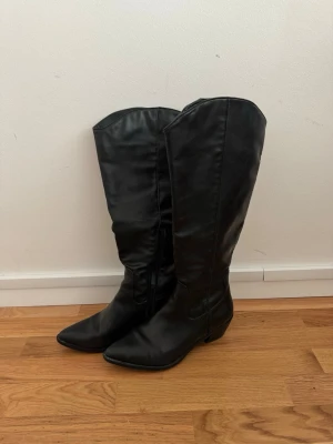 Svarta wide fit boots från Zalando! - Ett par svarta ”cowboy” eller ”biker” boots från zalando - Anna Field Pris på Zalando: 669kr  Just nu slutsålda på Zalando mellan storlek 38-43  Den är 5 cm i klack & har en ”wide fit” modell för bredare vader. På Zalando står det: ”denna produkt är liten i storleken. Vi rekommenderar att gå upp en storlek”  Jag är vanligtvis en storlek 39-40 men valde att köpa en 41 & den passar perfekt.  Säljs pga att jag aldrig använder dem tyvärr<3 använda 2 gånger! Fint skick💛  