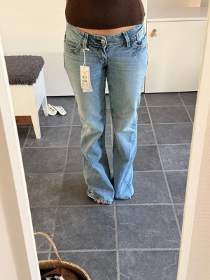 Ljusblå bootcut jeans - Snygga ljusblå bootcut jeans med klassisk femficksdesign och låg midja. 