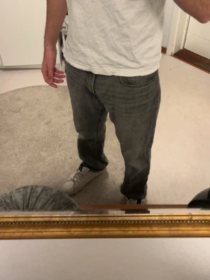 Grå loose fit jeans - Säljer ett par grå loose fit jeans med klassisk femficksmodell och rak passform. Jeansen har en avslappnad look och är tillverkade i denim. Perfekta för dig som gillar en chill och enkel stil. Jag är 178 lång och jeansen sitter bra. Köpte för 2 år sedan, inte använt dem. 