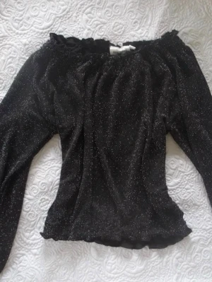Svart glittrig Offshoulder topp - Svart Offshoulder topp, storlek 134/140 men passar som en xs!🤍