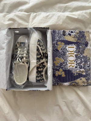 Dior walk n skor  - Snygga låga sneakers Märket Christian Dior syns tydligt på plösen och sidan. Perfekta för dig som vill ha en lyxig och trendig look. Helt nya har inte använts sälj på grund av fel st och fick det som födelsedag present. Pris kan diskuteras 