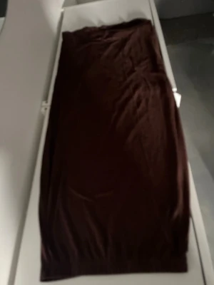 Brunt nattlinne i mjukt tyg - Mysigt nattlinne i en djup brun färg. Lång modell med enkel, rak passform och utan synliga detaljer eller mönster. Perfekt för avslappnade kvällar hemma. Materialet ser ut att vara mjukt och bekvämt, troligen bomull eller viskos.
