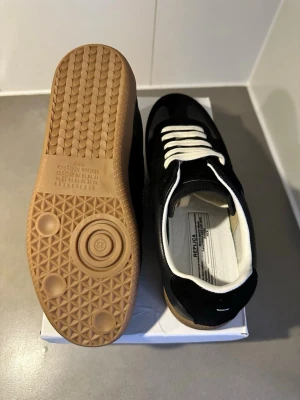 Masion margella skor kvitto finns  - Säljer ett par nästan oanvända Masion Margiella  Sneakers i mycket fint skick. Klassisk modell i svart läder med vita snören och gum sole. Kommer med originalbox.
