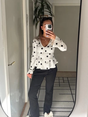 Vit prickig blus med v-ringning - Vit blus från Gina tricot med svarta prickar och v-ringad hals🤍 Blusen har långa ärmar, markerad midja och volang nedtill som faller kroppen perfekt😚 Så fin att både styla upp eller ner och har endast testat den, använd gärna KÖP NU🥂 