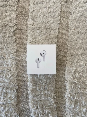 AirPods 4 ANC - Säljer ett par Apple AirPods 4:e generationen i originalförpackning. Trådlösa in-ear hörlurar i vit färg med stilren och kompakt design. Laddningsetui i hårdplast ingår. Perfekta för musik, samtal och träning.