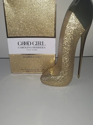 Good Girl Glorious Gold EdP 80ml - Good Girl Glorious Gold Collector Edition från Carolina Herrera. Parfymen kommer i en lyxig, glittrig guldfärgad flaska formad som en högklackad sko. Rymmer 80 ml Eau de Parfum och är en riktig statement-piece på parfymhyllan.