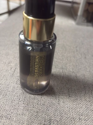 Sebastian Dark Oil 30ml hårserum - Sebastian Dark Oil är en lyxig hårolja i en svart och guld glasflaska med pump. Innehåller 30 ml och passar perfekt för att ge glans och mjukhet till håret. Oljan har en elegant design och är enkel att använda för styling och vård.