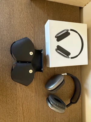 Apple AirPods Max hörlurar grå - Snygga Apple AirPods Max i rymdgrå färg. Over-ear design med mjuka öronkuddar och justerbart huvudband i metall och mesh. Kommer med originalförpackning och smart skyddsfodral. Perfekta för musik, gaming eller film.