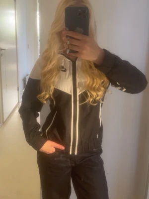 Svartvit vindjacka från Nike - Vindjacka från Nike. Använd kanske 1-2 gånger max så i nyskick!