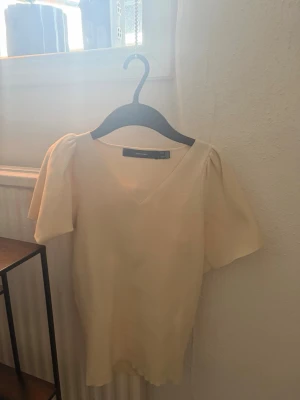 krämvit topp med volanger - Säljer en krämvit topp i nytt skick från veromoda , aldrig användt. Storleken känns mer som Xs/ S. Säljer pga inte kommer till användning.