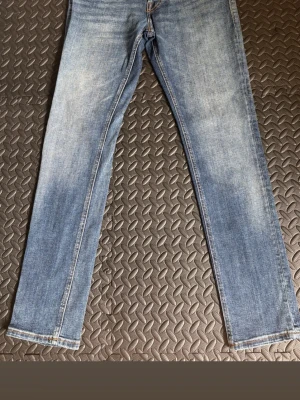 Blå slim fit jeans från Jack & Jones  - Säljer ett par klassiska blå slim fit jeans från Jack & Jones . Jeansen har en snygg tvätt med lätt slitning, raka ben och fem fickor. Tillverkade i bomull med en skön stretch. Perfekta för dig som gillar en enkel men stilren look.