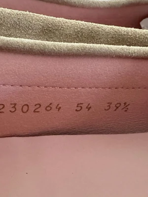 Beige loafers från Pretty Ballerinas - Snygga beige loafers från Ralph Lauren i mjukt mockaskinn. Klassisk penny loafer-design med sömmar runt tån och rosa innersula. Perfekta för en clean och stilren look.