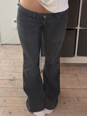 Mörkblå bootcut jeans - Snygga mörkblå bootcut jeans med låg midja och klassiska fem fickor. Jeansen har subtila slitningar framtill och är tillverkade i ett stretchigt denimtyg som sitter skönt. Perfekta för en avslappnad och trendig look. Slitna längst ner på byxbenen!