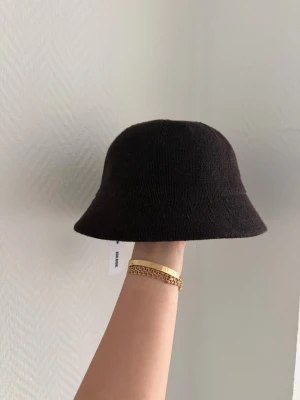 Brun stickad bucket hat - Säljer en brun stickad bucket hat med enkel och stilren design. Hatten har mjuk struktur och bred brätte som ger en avslappnad look. Perfekt accessoar för att lyfta din outfit och funkar året runt. Lapp från märket syns på insidan. 