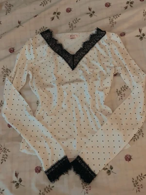 Prickig långärmad topp från Gina 🌸 - Vit långärmad topp från Gina Tricot med svarta prickar och spetsdetaljer, använt ungefär 2-3 gånger sen köptes 💗