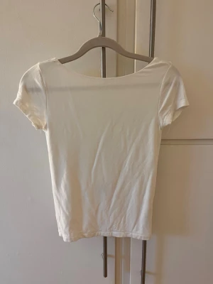 Vit topp med öppen rygg - Vit T-shirt med öppen rygg.