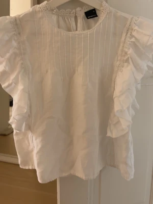 Vit blus med volanger - Supersöt vit blus ifrån Gina Tricot. Perfekt inför sommaren.
