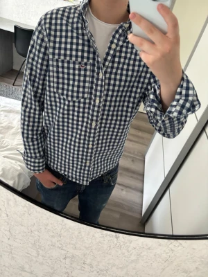 Hollister skjorta - Hollister skjorta i mycket bra skick, inga defekter! Storlek S men kan även passa M. Modellen på bilden är 170, 60kg! Hör av er vid frågor eller minsta fundering 🙌  Se mått nedan:  Längd: 65 cm  Bred: 47 cm  Ärm: 60 cm