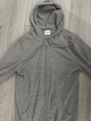 John Henric zip cashmir  - Säljer en John Henric Zip hoodie i cashmir i bra skick. Enda problemet är ett väldigt litet hål i luvan men syns knappt. Storlek M