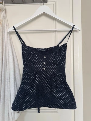 Svart prickig linnetopp med knappar - En jättefin topp ifrån brandy Melville. I storlek xs. Använd några gånger❤️