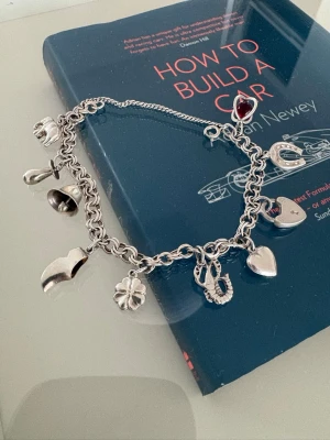 Berlockarmband i silver med charms - Säljer ett vintage charmarmband med flera olika berlocker. Älta silver som är stämplat 835.   Fint använt skick med lite vanligt slitage. Säljer eftersom det inte kommer till användning längre.  Skriv gärna om du vill ha fler bilder eller information. 