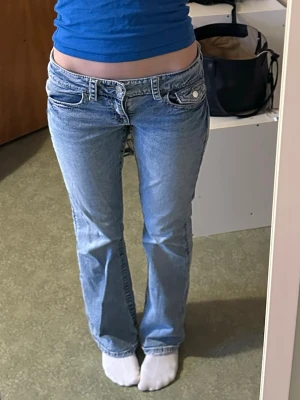 Ljusblå bootcut jeans - Säljer ett par ljusblå jeans från Gina Tricot i storlek 158(jag är 168). Jeansen har bootcut-modell med låg midja och fickor fram och bak. Innerbensländ: 76cm