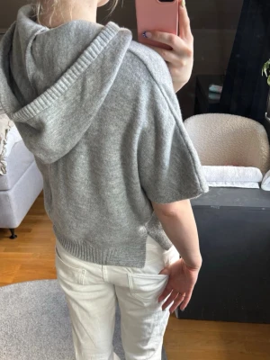 Stickad hoodie - Snygg grå stickad hoodie med korta ärmar! Knappt använd, nypris 799kr💗 Priset är diskuterbart vid snabb affär!🥰
