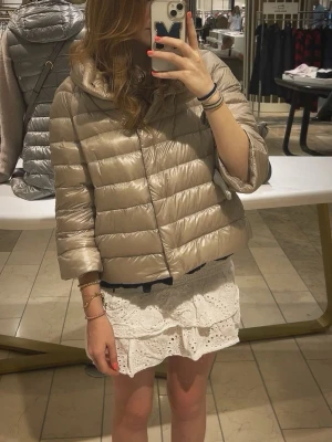 Beige dunjacka från Herno - Snygg beige dunjacka från Herno med glansigt material och kontrasterande gråblå detaljer längs kanterna. Perfekt om du gillar Stockholmstil. ‼️ JAG ÄR VILLIG ATT DISKUTERA PRISET VID SNABB AFFÄR‼️