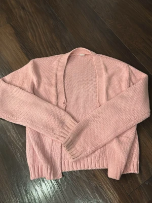 Rosa stickad tröja från Lindex - Jättefin vårig rosa stickad kofta från Lindex i storlek 158/164. Två lite frasiga ”hål” vid ”stängningen” av tröjan. Pris går att diskuteras!
