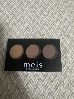 Meis ögonskuggspalett bruntoner - Ögonskuggspalett från Meis med tre matta nyanser i bruna toner. Paletten innehåller en ljus beige, en mellanbrun och en mörkbrun skugga. Kommer i en kompakt plastförpackning med genomskinligt lock och medföljande applikator.