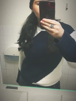 Mörkblå och vit stickad tröja - Säljer en snygg stickad tröja i mörkblått och vitt med diagonal färgblockdesign. Från Gina Young i storlek 170! Tröjan har rund halsringning och långa ärmar. Perfekt för dig som gillar en stilren och modern look under våren och sommarkvällarna.❤️