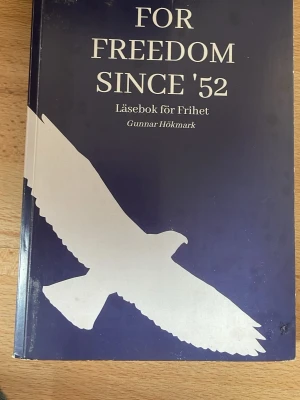 For Freedom Since '52 - Läsbok - En bok med titeln 'For Freedom Since '52' av Gunnar Hökmark. Omslaget är mörkblått med en stor vit siluett av en fågel. Boken handlar om frihet och demokrati i Europa, med texter om kampen mot diktaturer och för frihet från 1950-talet och framåt.