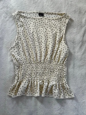 Prickig topp - Prickig crèmevit topp från Gina Tricot i storlek XL med mindre passform då den passar mig som använder storlek M. Endast använd 1 gång. 