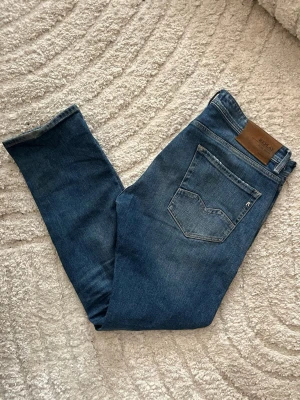 Replay Rocco jeans  - Klassiskt blåa Repaly jeans i modellen Rocco med en Comfort fit. Midja 47cm, längd 103cm. Obs jeanens benslut är lite slitna - se när bild. JAG SKICKAR EJ FLER BILDER NÄR JAG BÄR JEANSEN! för bättre inblick i passformen rekommenderar jag att googla på modellnamnet. För storleksguide kolla måtten noggrant då jeansen alltid kan vara uppsydda heller krympta och jag ej tar emot returer :) 1,96