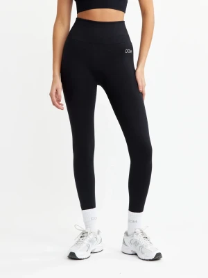 Svarta seamless leggings från DOM - Säljer ett par svarta seamless leggings från DOM med hög midja och tight passform. Diskret logga framtill och stretchigt material som sitter skönt på kroppen. Perfekta för träning eller chill dagar. Trycket har dock gått av lite men de är bra ändå!